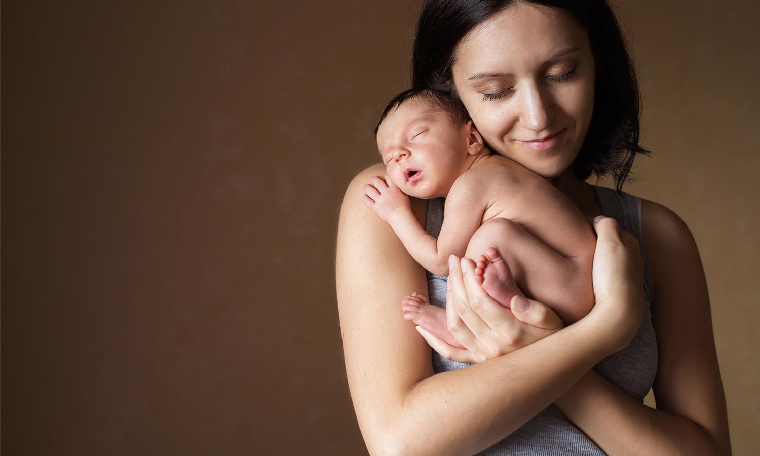 modernmamahypnobirthing-young-mother-holding-her-newborn