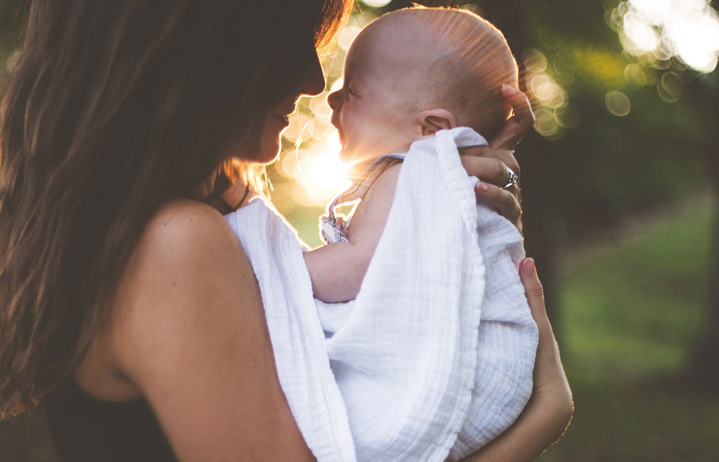 modernmamahypnobirthing-photo-of-a-mother-holding-her-baby-sunlight-outdoor