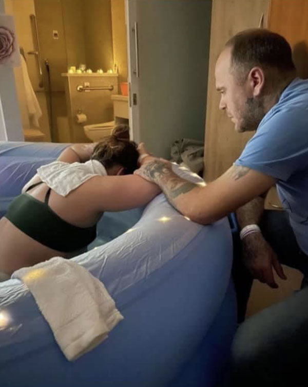 photo of a husband holding his wife's arm to comfort and support her during HypnoBirthing